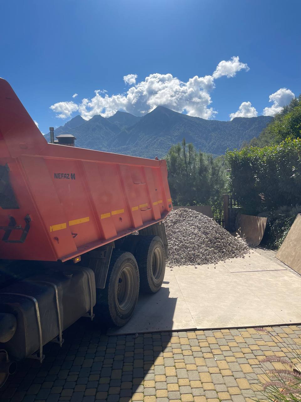 Выгрузка щебня на фоне гор Сочи